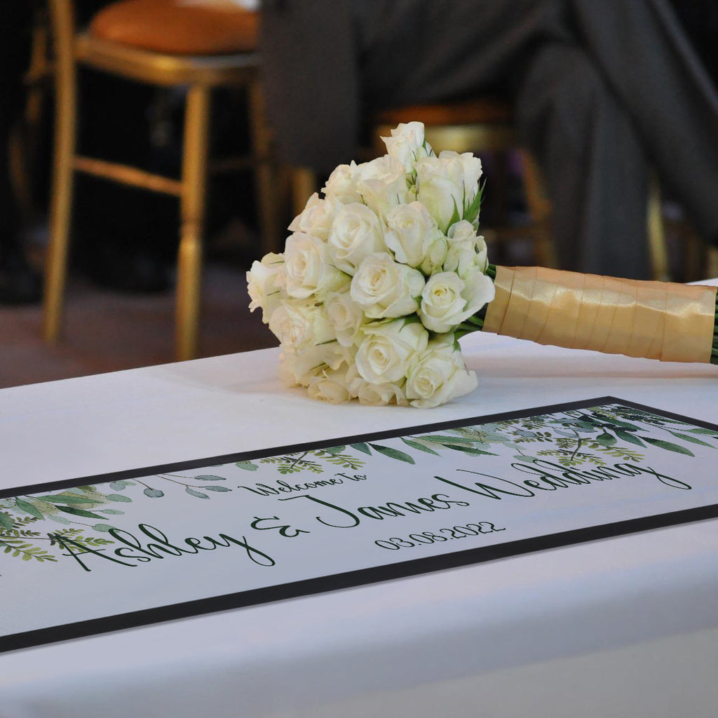 Personalised wedding bar runner with custom names and date on a silk table top at a UK wedding reception.