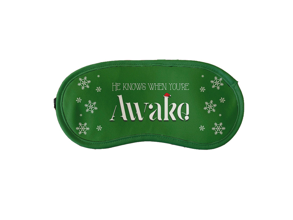 Green Christmas sleeping mask with festive text 'He knows when you're awake.' for a holiday-themed sleep accessory.